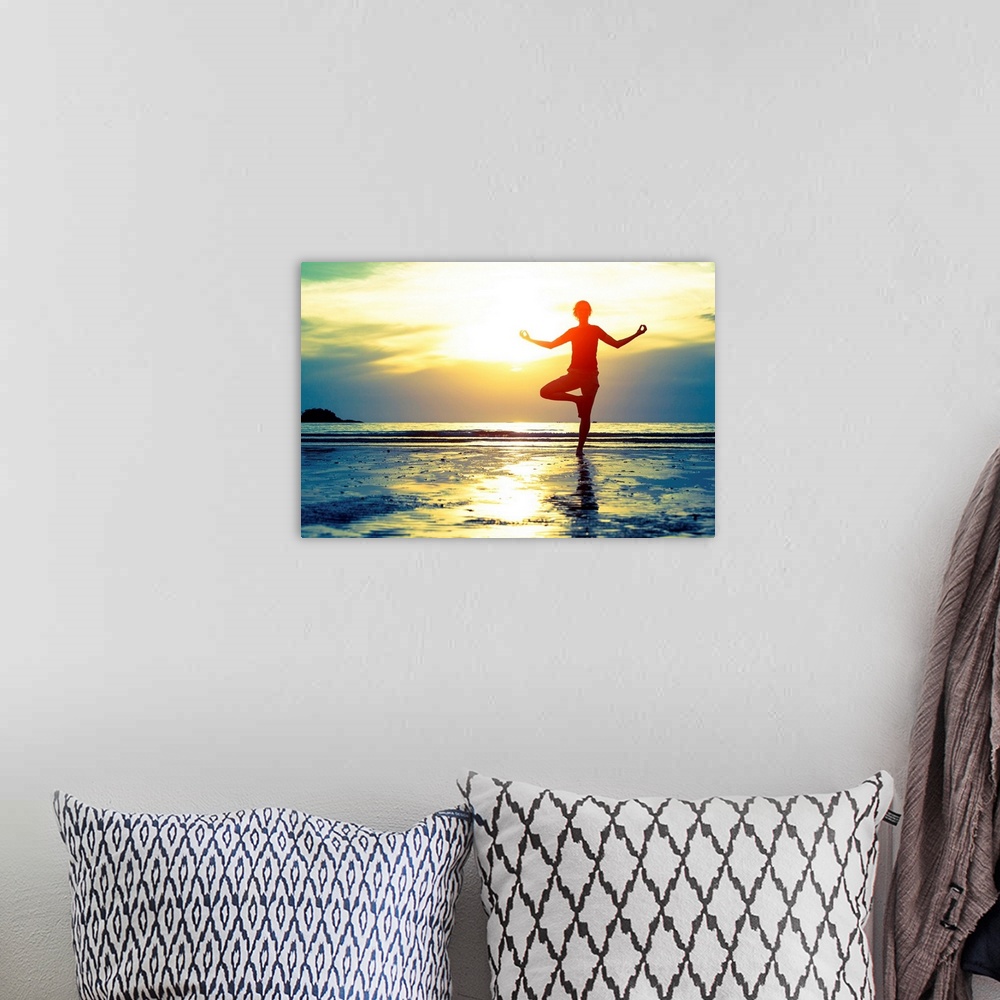 A bohemian room featuring Woman practicing yoga on the beach at sunset