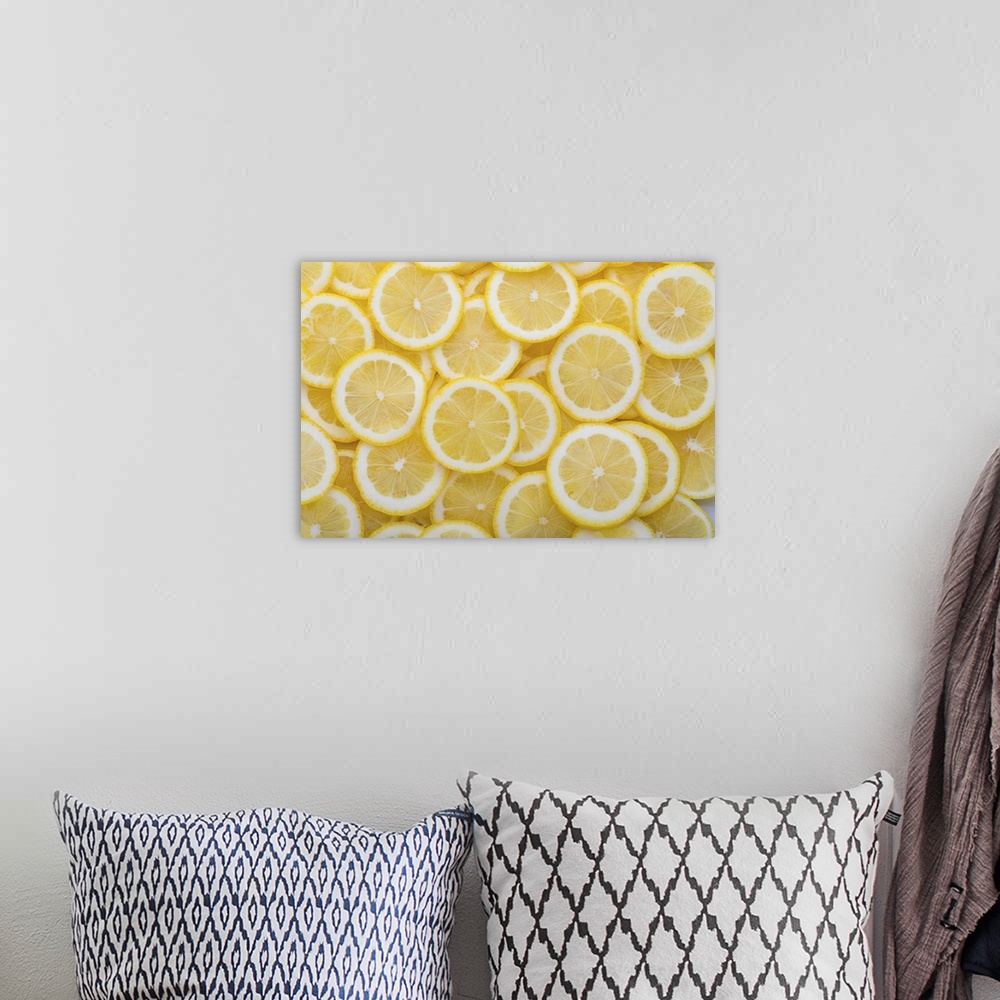 A bohemian room featuring Yellow sliced lemons places on a table overlapping each other. Background texture of fresh yellow...