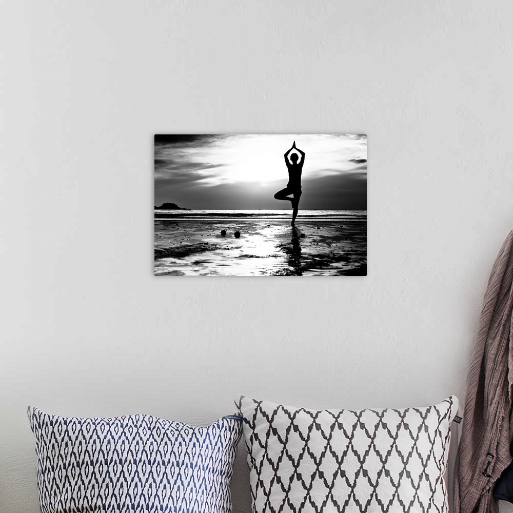 A bohemian room featuring Black and white picture: Young woman practicing yoga on the beach at sunset.