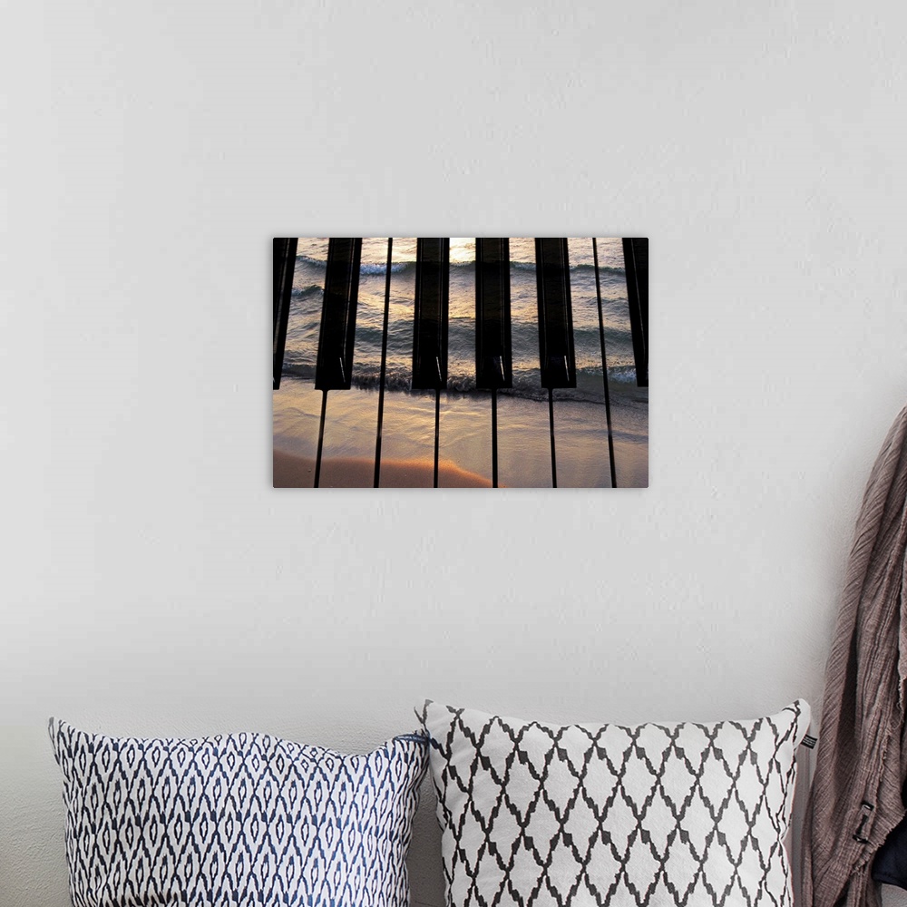 A bohemian room featuring Big photograph focuses on the keys of a piano that have another picture of a sea crashing into a ...