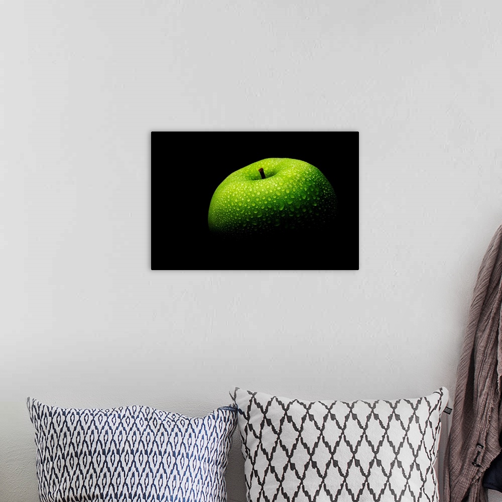 A bohemian room featuring A close up photograph of a fresh Granny Smith apple with waterdrops.