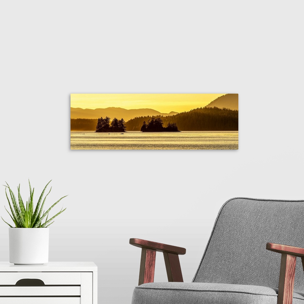 A modern room featuring A evening golden sunset overlooking islands and mountains of the Pacific Northwest of Vancouver I...