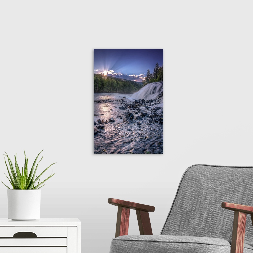 A modern room featuring Sunrise breaming over the edge of a mountain range with gentle waterfalls in the foreground.