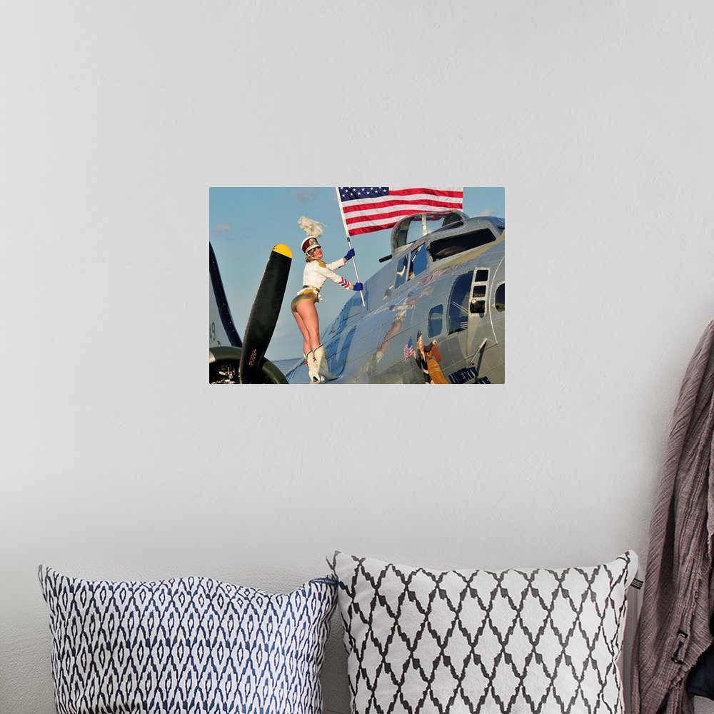A bohemian room featuring Patriotic 1940's style majorette pin-up girl standing on a B-17 bomber with an American flag.