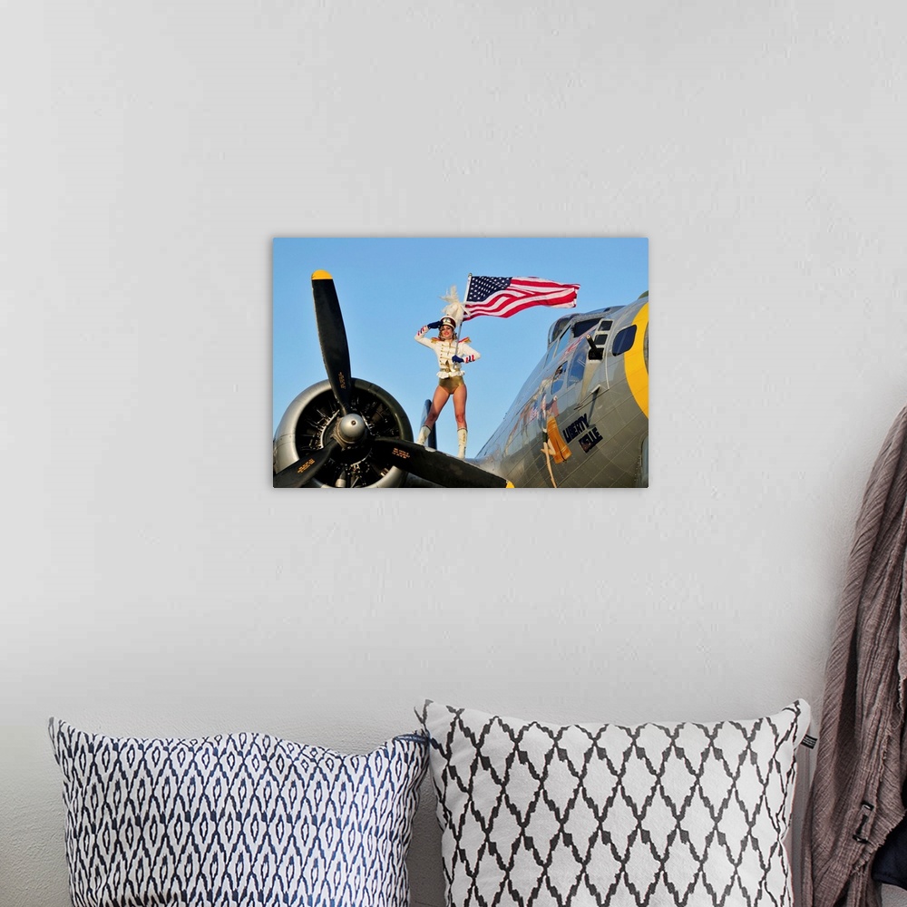 A bohemian room featuring Patriotic 1940's style majorette pin-up girl standing on a B-17 bomber with an American flag.