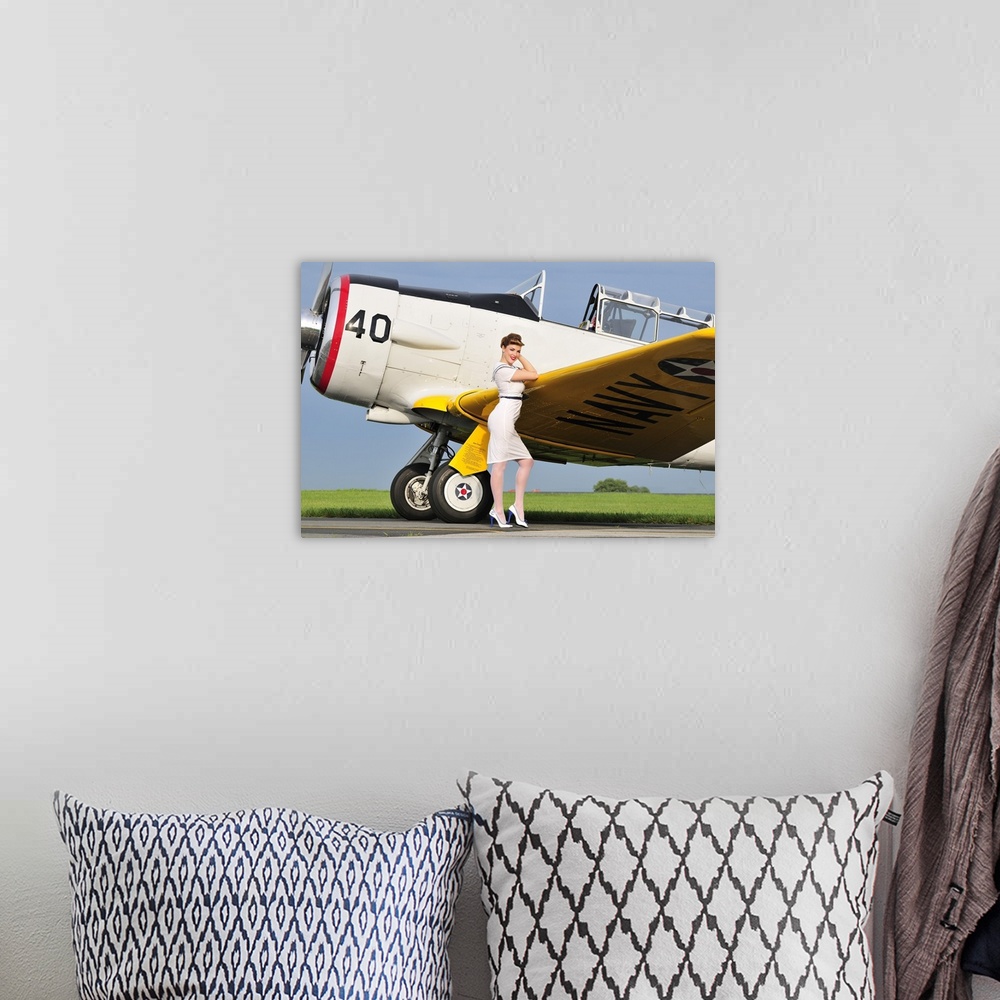 A bohemian room featuring 1940's style Navy pin-up girl leaning on the wing of a T-6 Texan trainer aircraft.