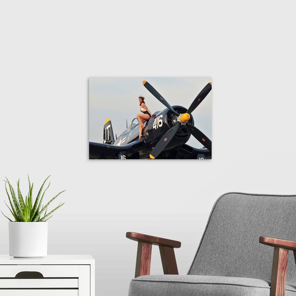 A modern room featuring 1940's style Navy pin-up girl sitting on a vintage World War II Corsair fighter plane.