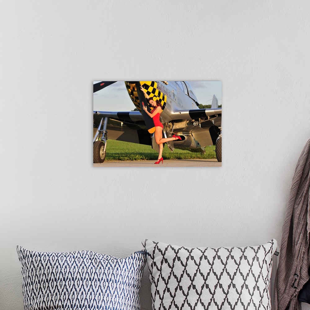 A bohemian room featuring Sexy 1940's style pin-up girl posing with a P-51 Mustang fighter plane.