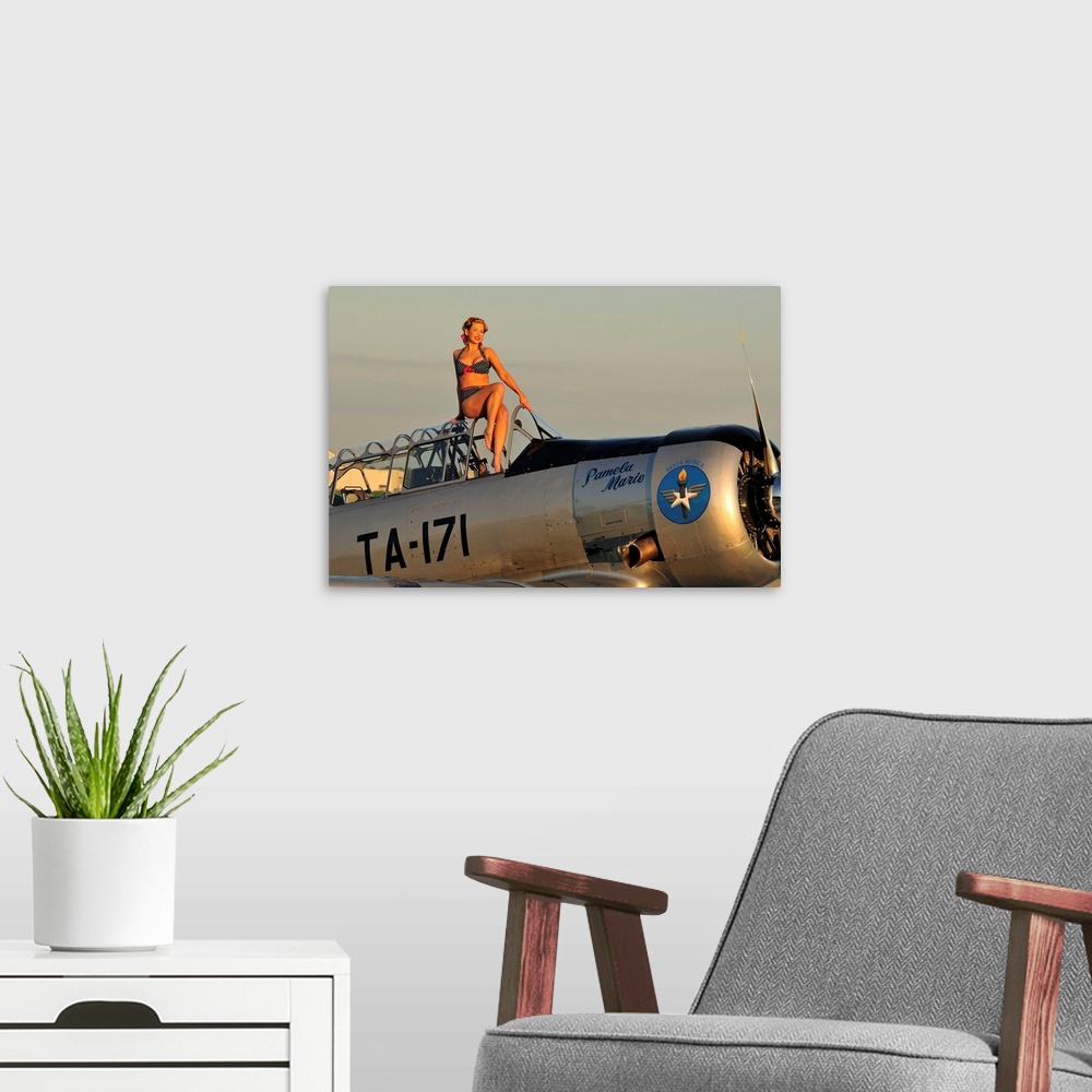 A modern room featuring 1940's style pin-up girl sitting on the cockpit of a World War II T-6 Texan.