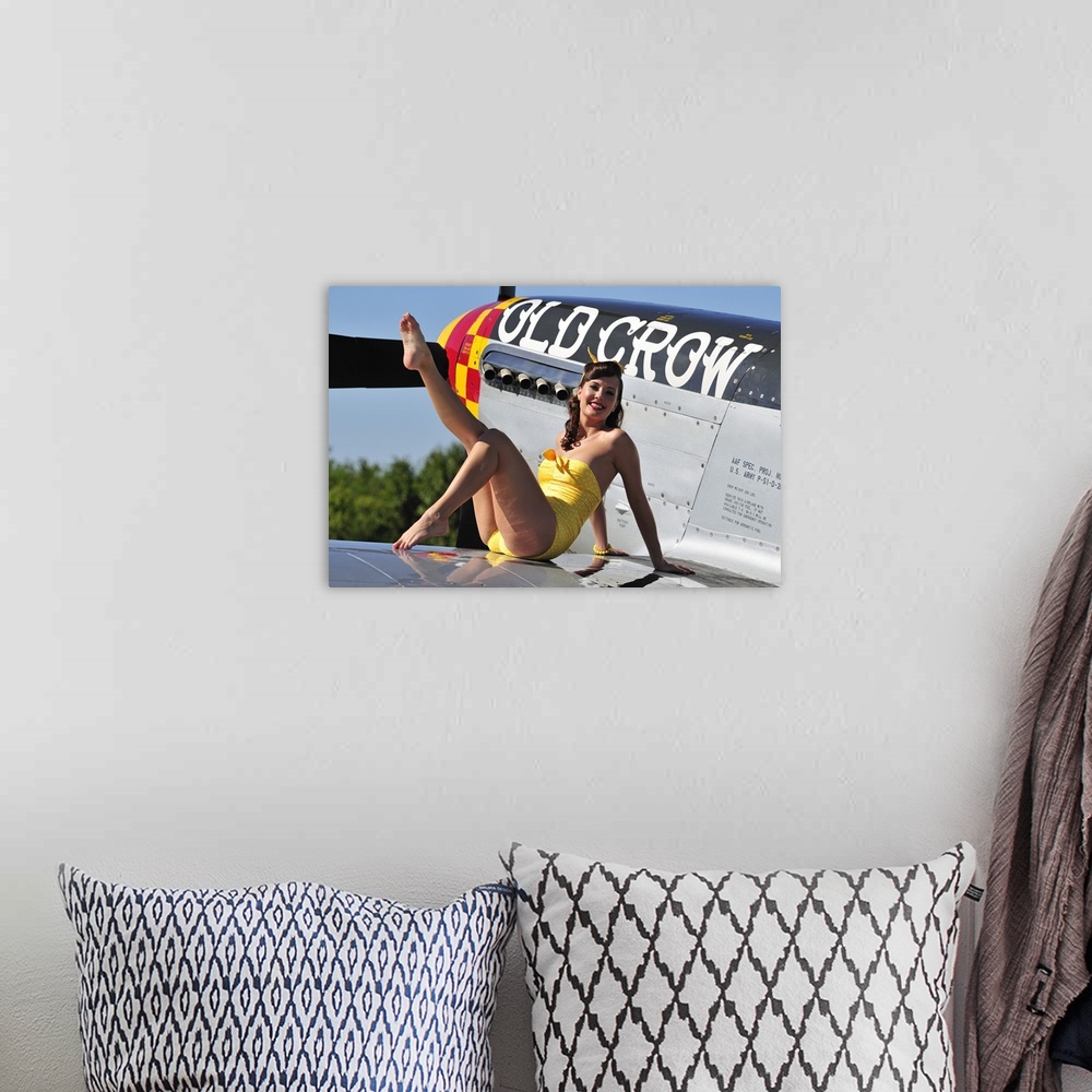 A bohemian room featuring Cute pin-up girl sitting on the wing of a World War II era P-51 Mustang fighter plane.