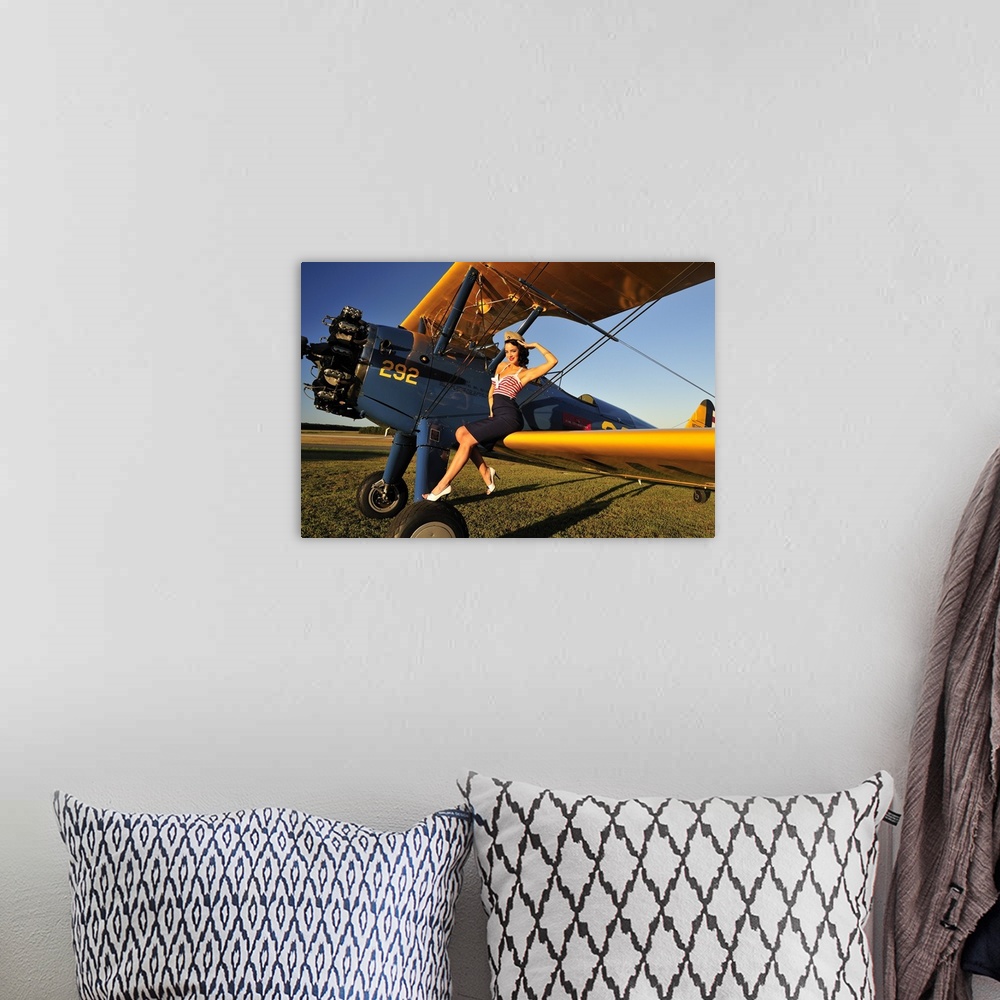 A bohemian room featuring Patriotic 1940's style pin-up girl sitting on the wing of a World War II Stearman biplane.