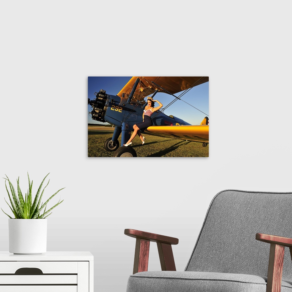A modern room featuring Patriotic 1940's style pin-up girl sitting on the wing of a World War II Stearman biplane.