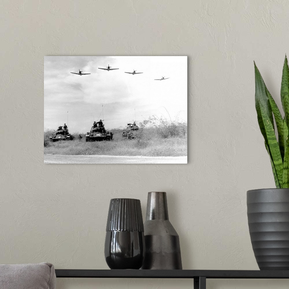 A modern room featuring A-1H aircraft make a low level pass over Vietnamese tanks and ground troops, 1963.