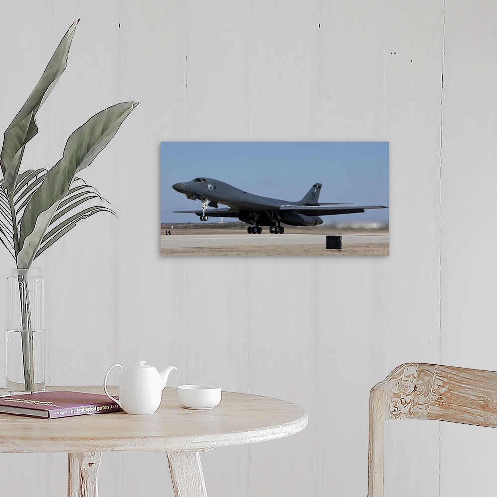 A farmhouse room featuring A 7th Bomb Wing B-1B Lancer takes off in the late afternoon from Dyess Air Force Base, Texas.