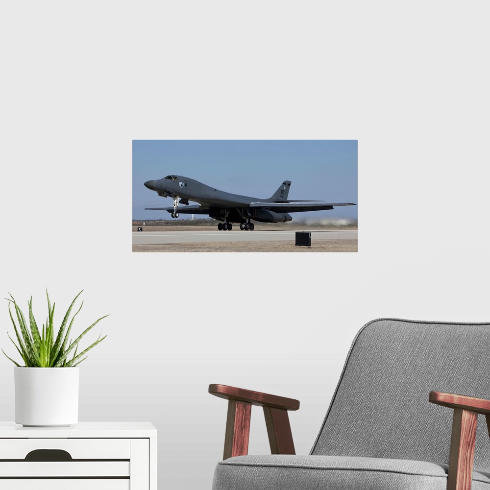 A modern room featuring A 7th Bomb Wing B-1B Lancer takes off in the late afternoon from Dyess Air Force Base, Texas.