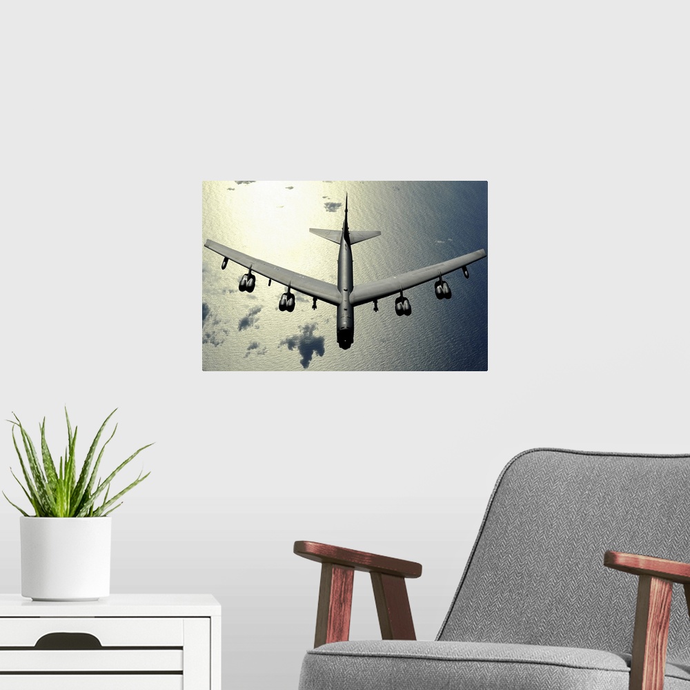 A modern room featuring Horizontal aerial photograph on a  big wall hanging, looking down at the top of a B52 Stratofortr...