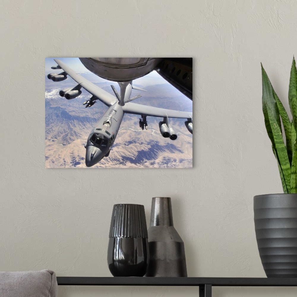 A modern room featuring This horizontal photograph has been taken from the underside of an aerial refueling aircraft duri...