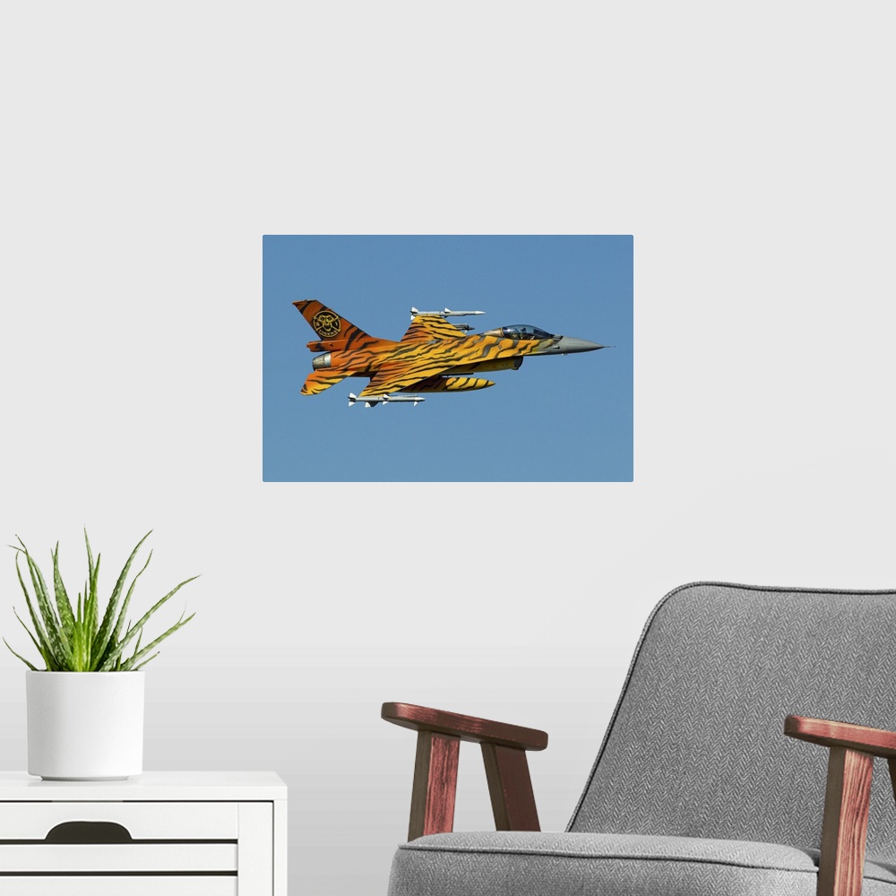 A modern room featuring A Belgian Air Component F-16 Fighting Falcon, painted in tiger colors for the NATO Tiger Meet, in...