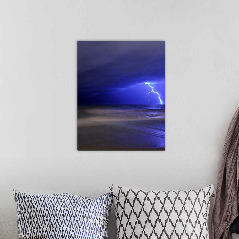 A bohemian room featuring Portrait photograph on a big canvas of a large bolt of lightening illuminating the cloudy night s...