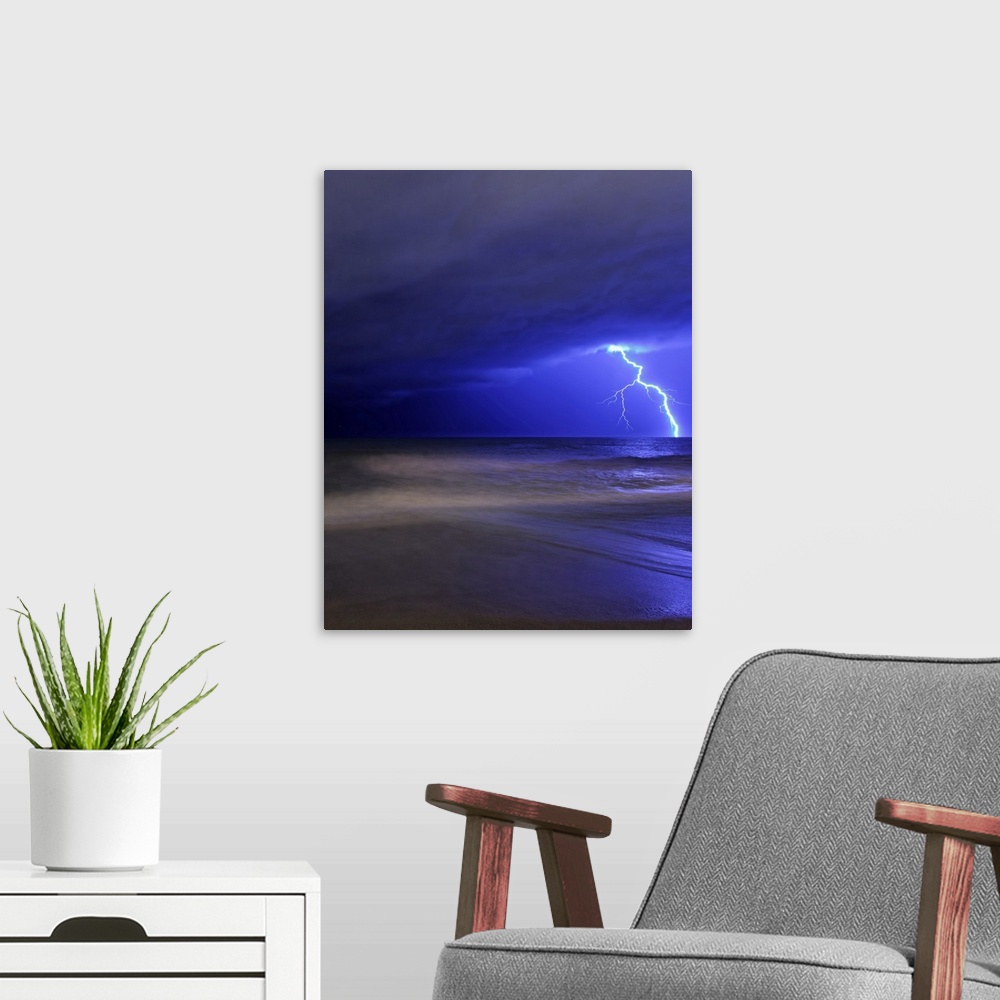 A modern room featuring Portrait photograph on a big canvas of a large bolt of lightening illuminating the cloudy night s...