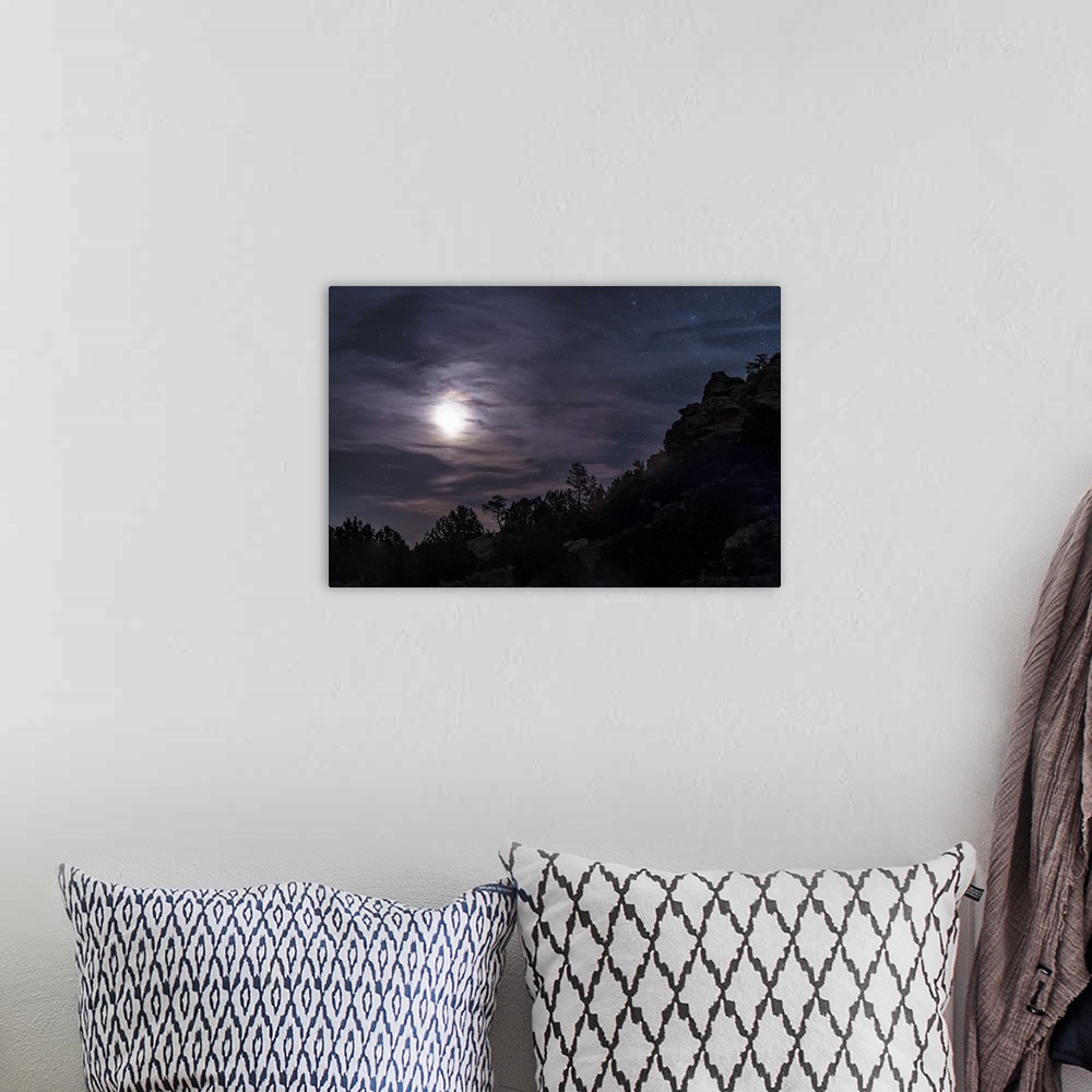 A bohemian room featuring A bright moon rises through clouds over a hill in Oklahoma, USA.