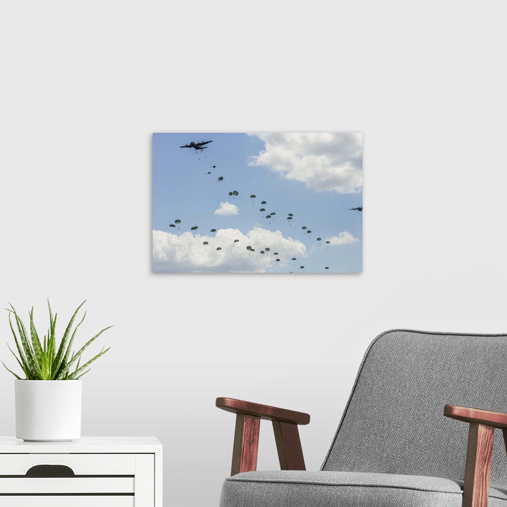 A modern room featuring U.S. Air Force C-130 Hercules drop U.S. Army airborne troops over Andrews Air Force Base, Maryland.