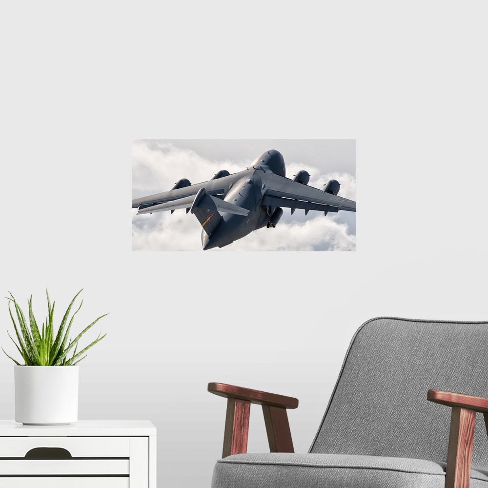 A modern room featuring Rear view of a C-17 Globemaster flying above the clouds over Nellis Air Force Base, Nevada.