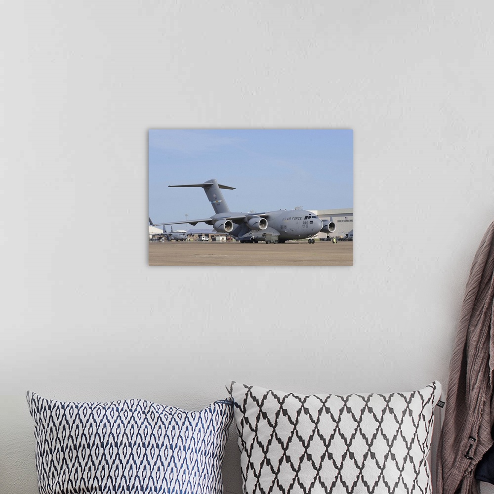 A bohemian room featuring A C-17 Globemaster III parked on the ramp at an Air Force base.