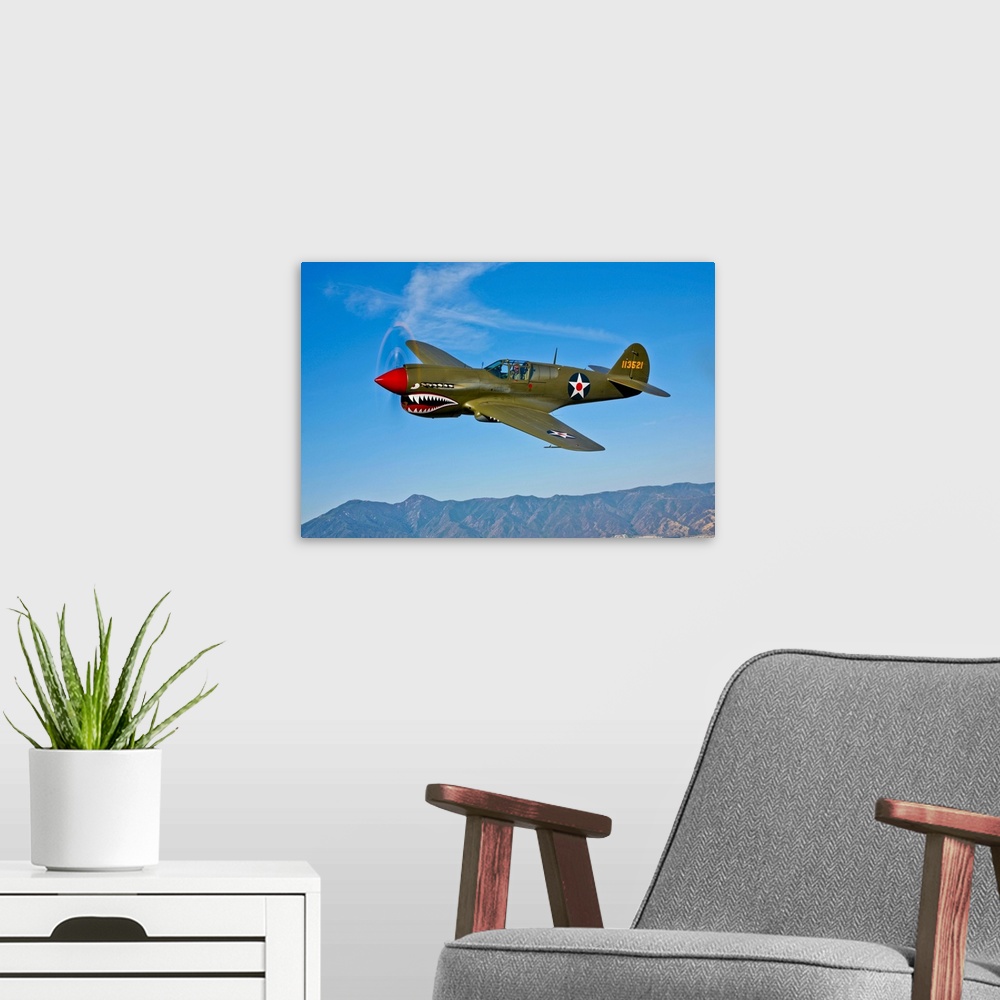 A modern room featuring A Curtiss P-40E Warhawk in flight near Chino, California.