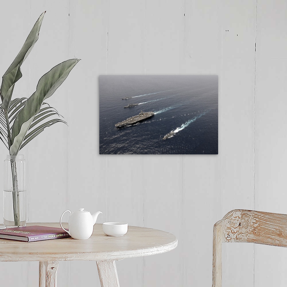 A farmhouse room featuring A formation of ships traveling at sea.