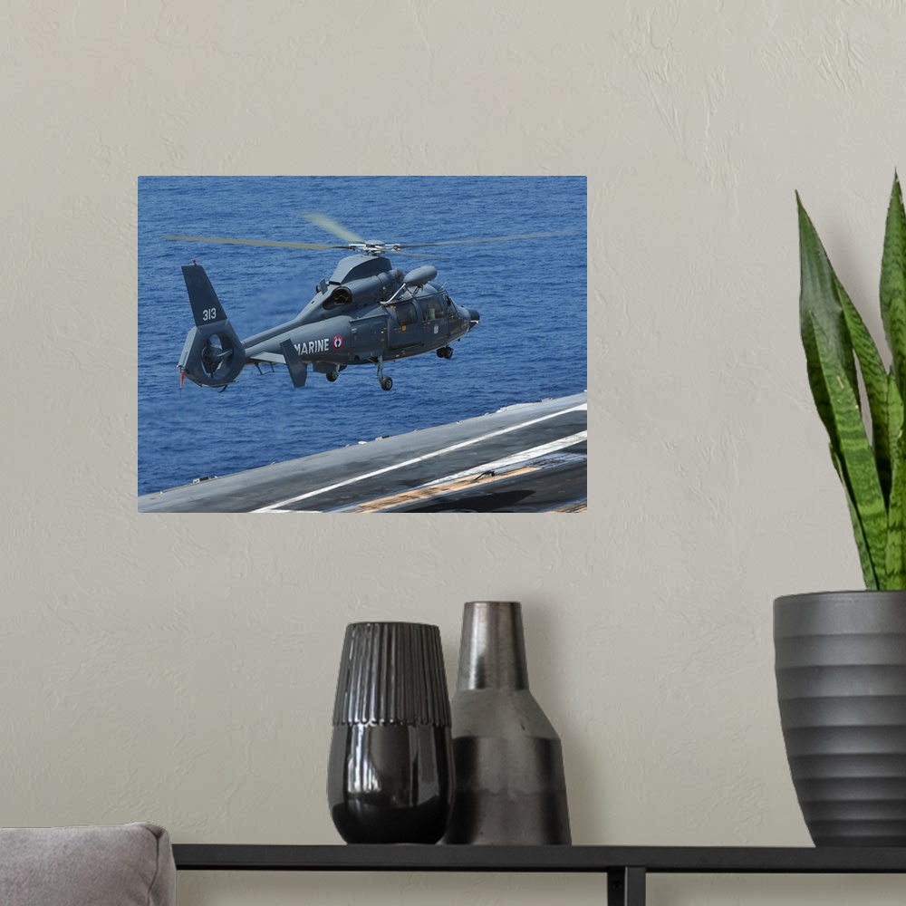 A modern room featuring A French Dolphin 35F helicopter takes off from the flight deck of USS John C. Stennis.