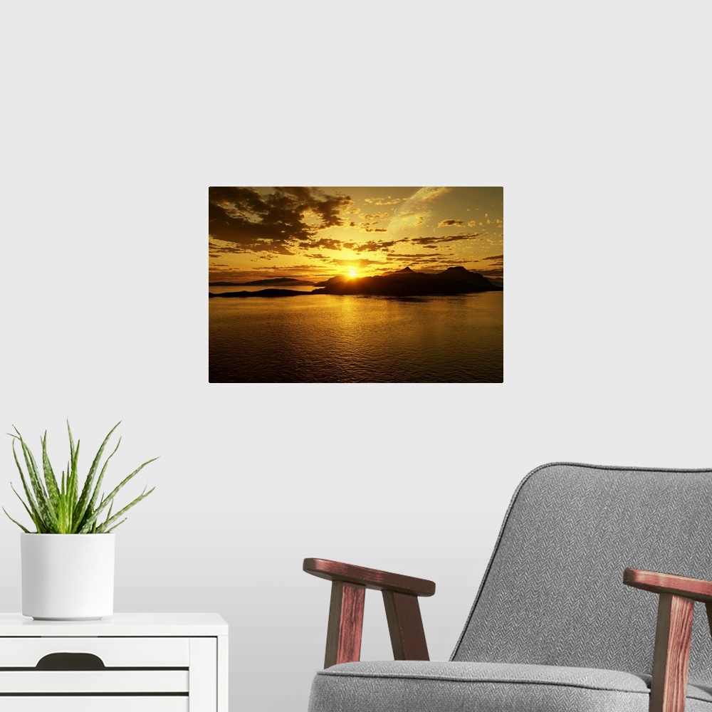 A modern room featuring A gas giant and multiple moons look down on a beautiful island sunset.