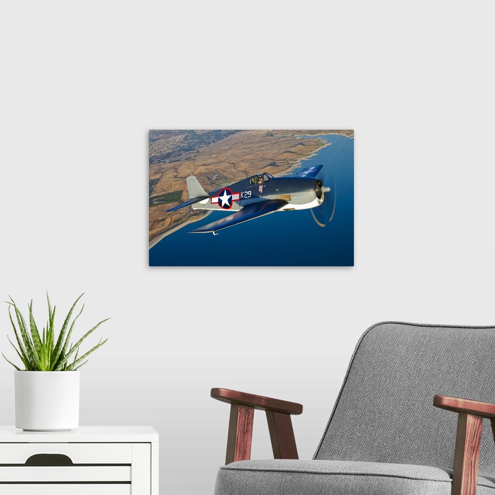 A modern room featuring A Grumman F6F Hellcat fighter plane in flight over Chino, California.