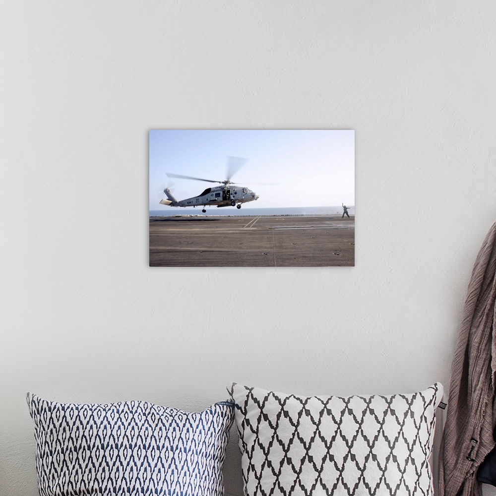 A bohemian room featuring A helicopter landing signalman directs an SH-60F Sea Hawk.