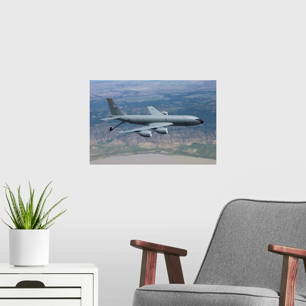 A modern room featuring A KC-135R Stratotanker from the 97th Air Mobility Wing lowers it's boom to prepare to recieve air...