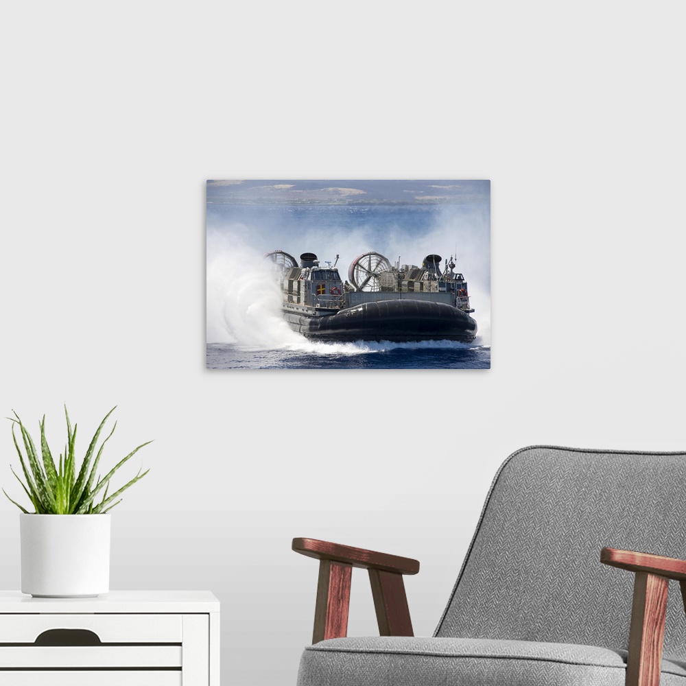 A modern room featuring Pacific Ocean, July 23, 2014 - A landing craft air cushion prepares to embark the well deck of th...