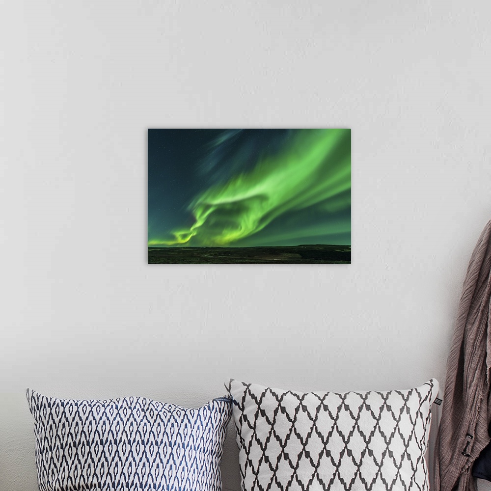 A bohemian room featuring A large aurora borealis display in Iceland.