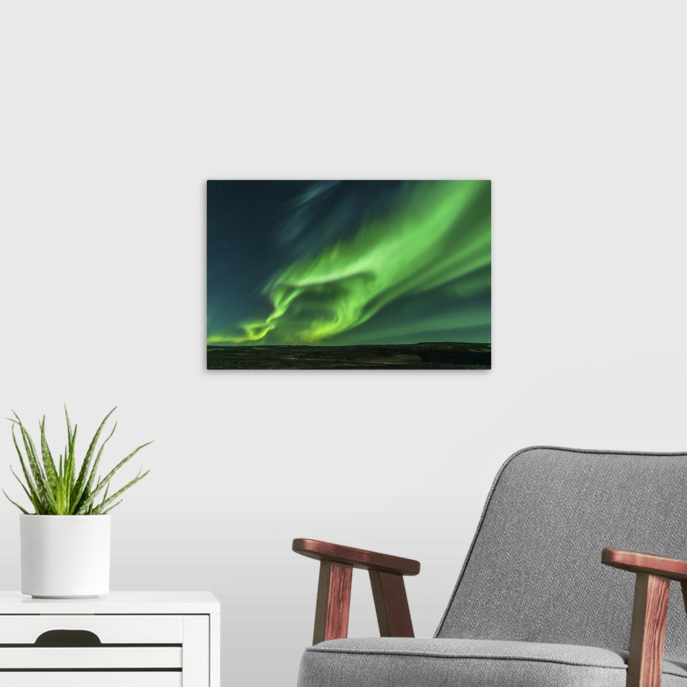 A modern room featuring A large aurora borealis display in Iceland.