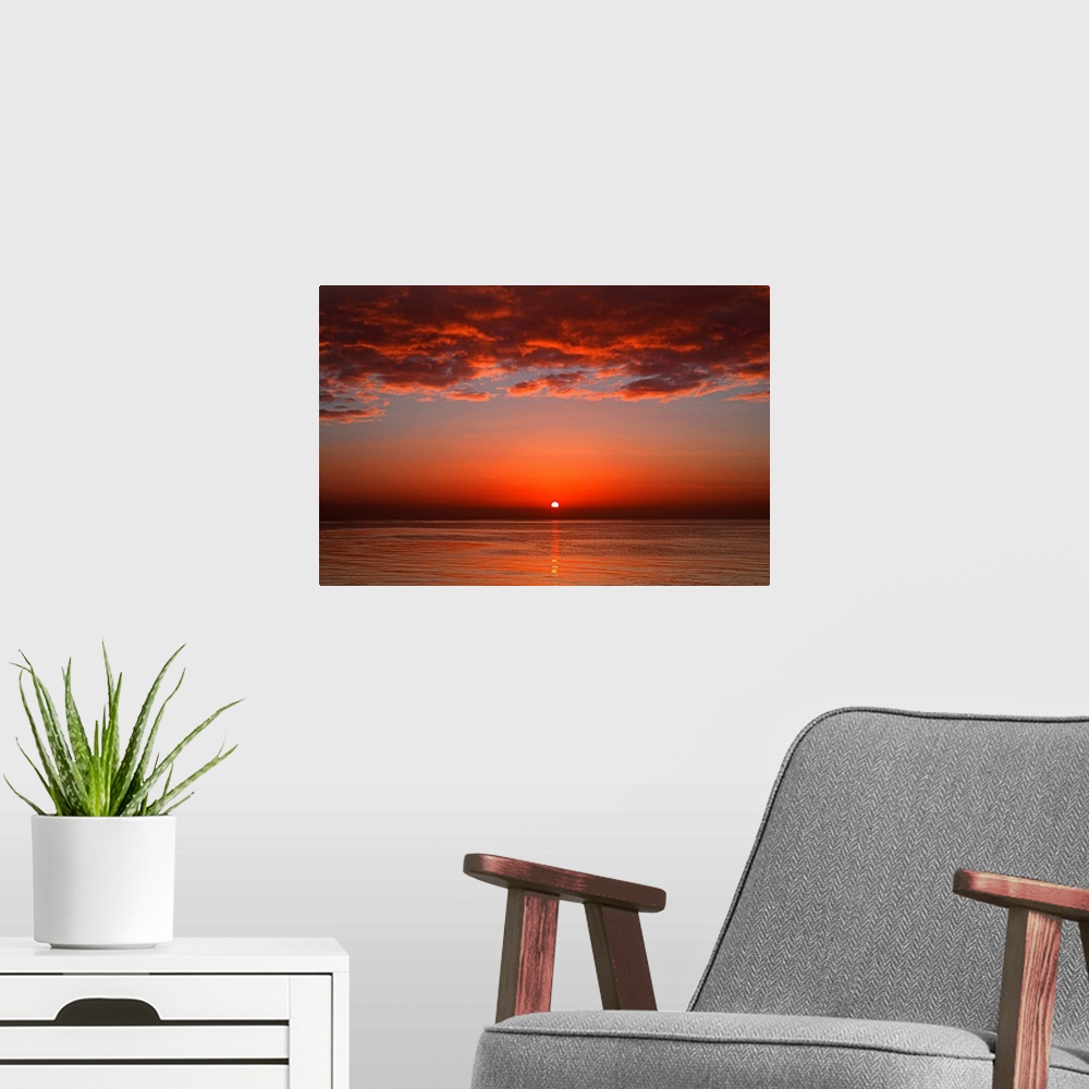 A modern room featuring A layer of clouds is lit by the rising sun over Rio de la Plata, Buenos Aires, Argentina.
