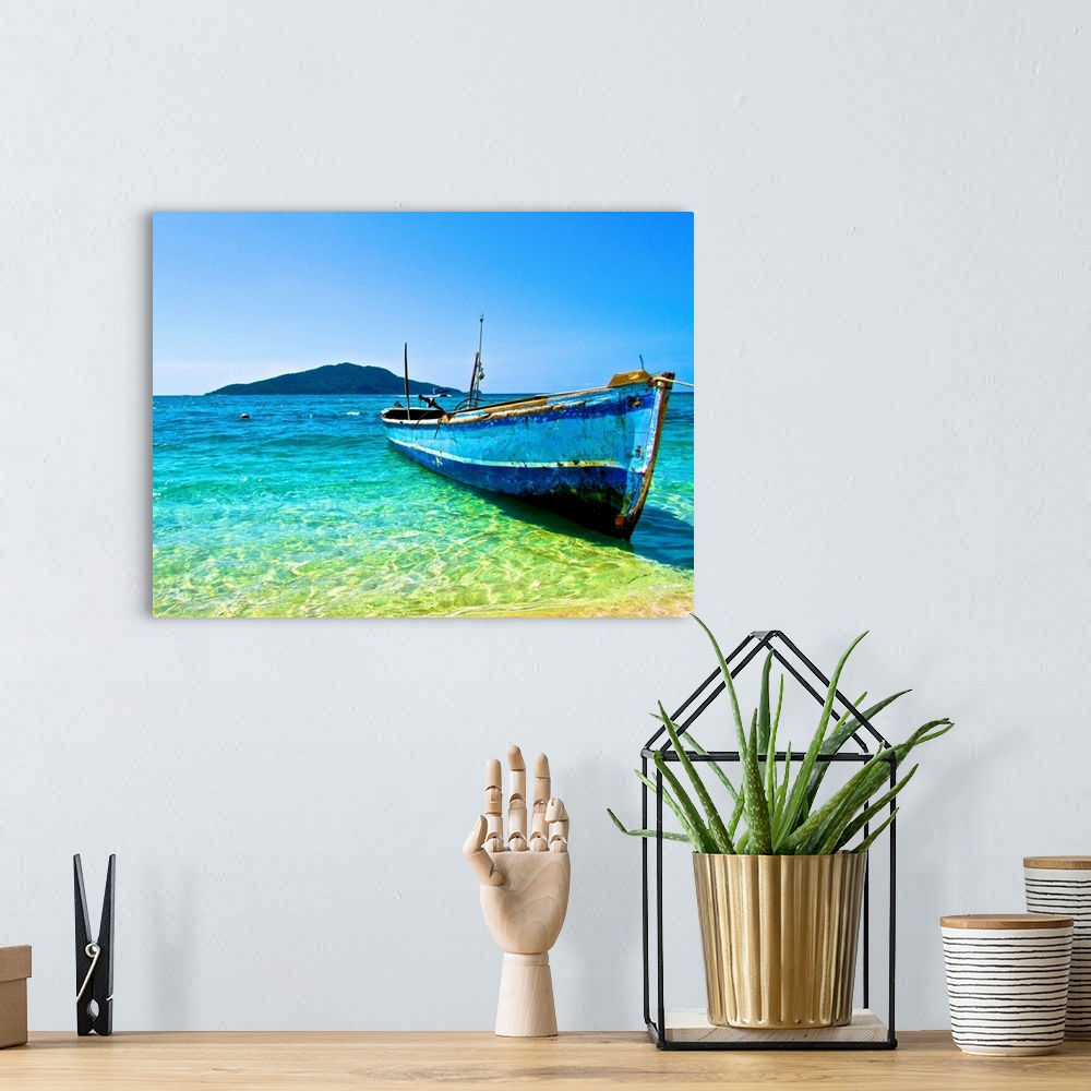 A bohemian room featuring A lone boat on the shore of Cayos Cochinos, Honduras.