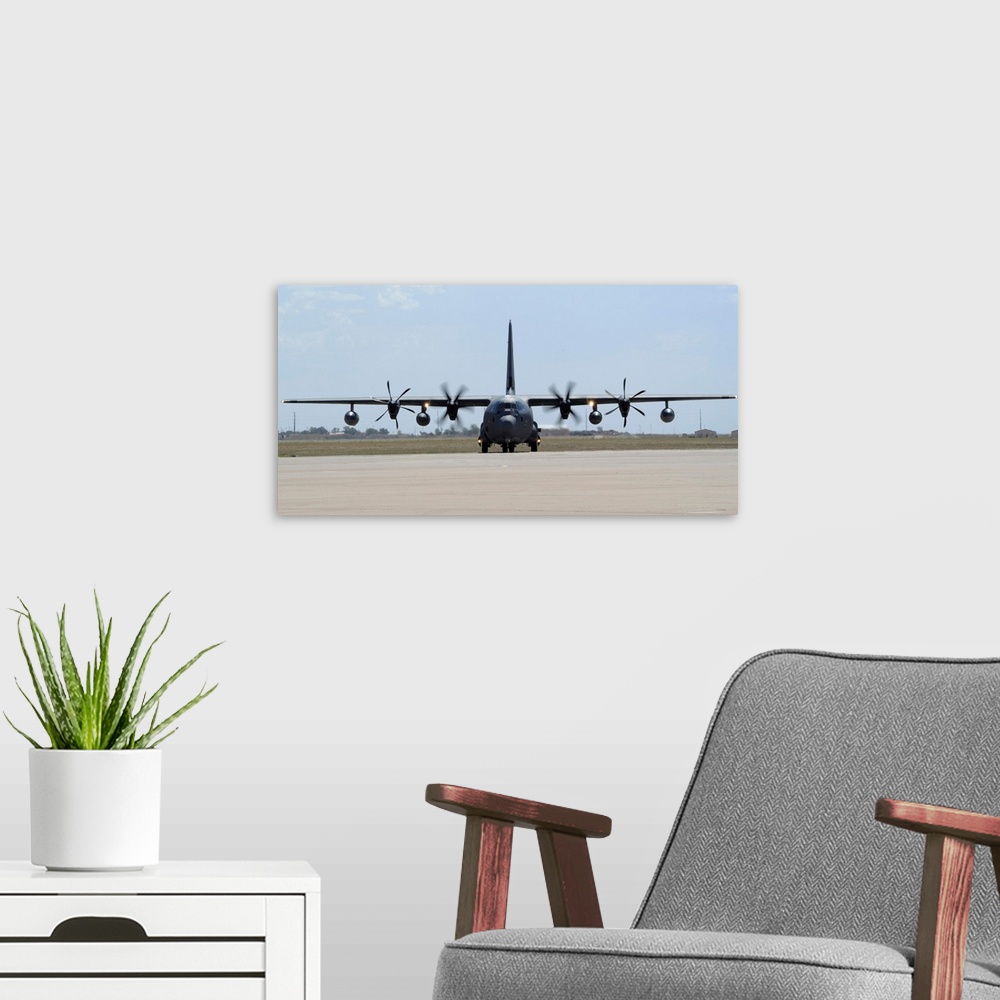 A modern room featuring A MC-130J Combat Shadow II taxis on the flight line.