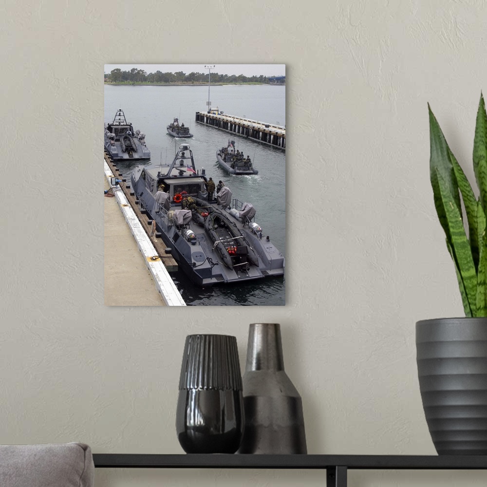 A modern room featuring A MKV Special Operations Craft tied pierside manned and loaded