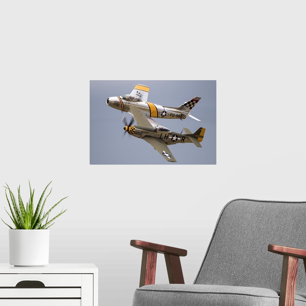 A modern room featuring A P-51 Mustang and F-86 Sabre of the Warbird Heritage Foundation carry out a heritage pass at Wau...