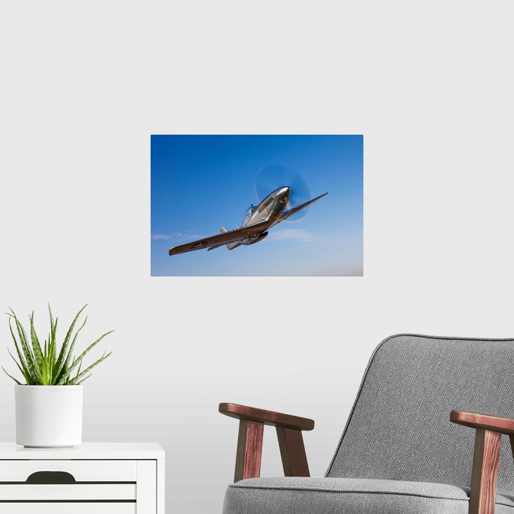 A modern room featuring Landscape photograph on a large canvas of a P-51D Mustang in flight, against a bright blue sky ne...