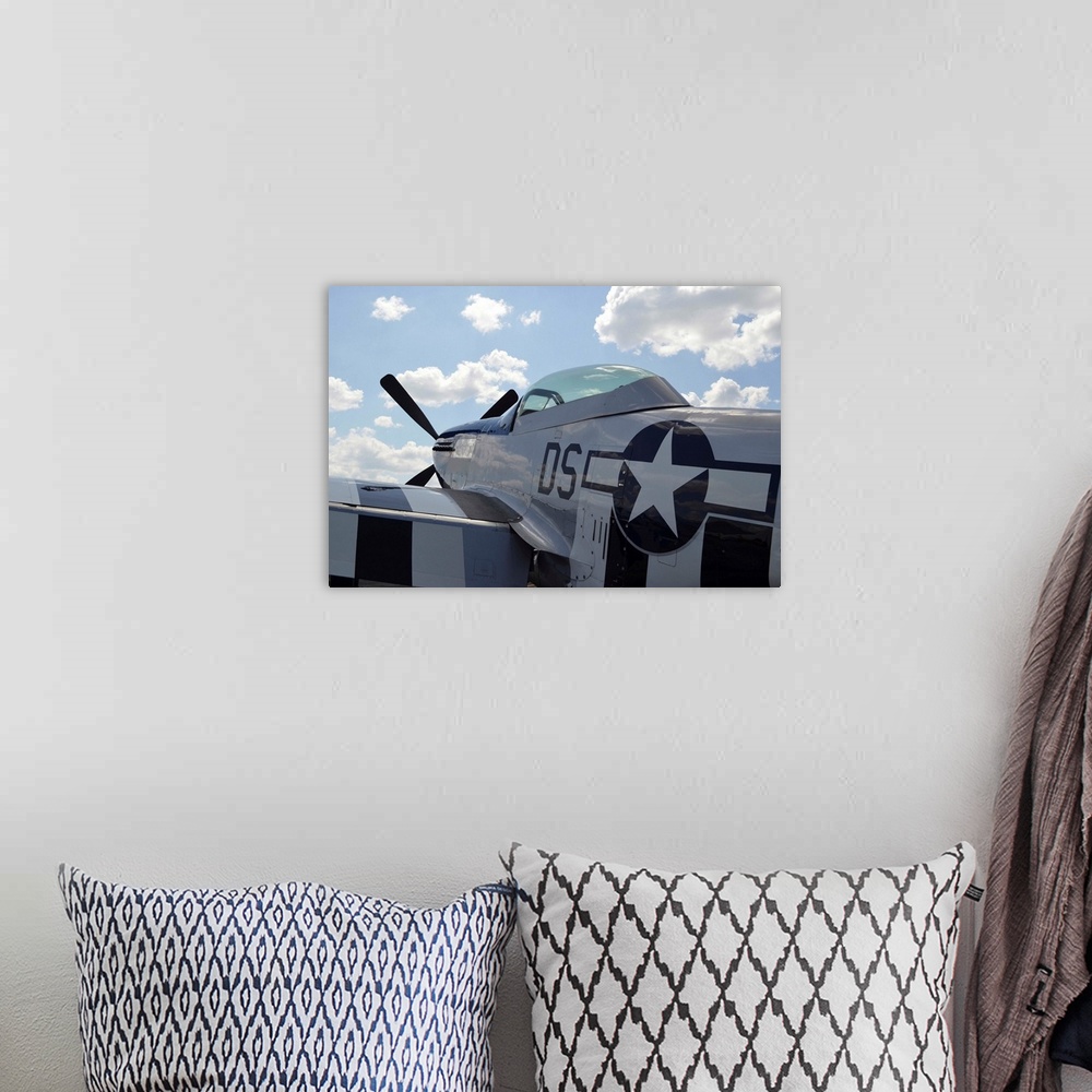 A bohemian room featuring A P-51D Mustang parked on the flight line.
