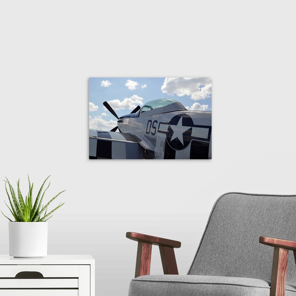 A modern room featuring A P-51D Mustang parked on the flight line.
