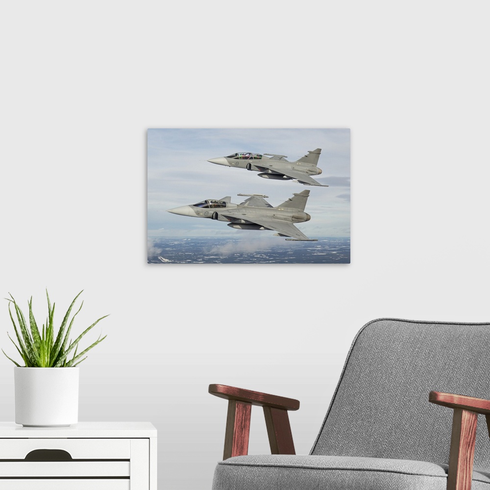 A modern room featuring A pair of Swedish Air Force JAS-39 Gripen fighter jets in flight over northern Sweden.