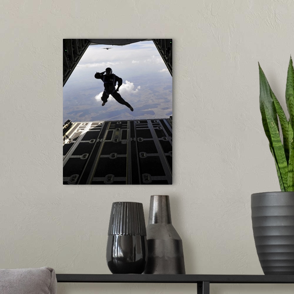 A modern room featuring March 18, 2011 - A paratrooper salutes as he exits a C-130J Super Hercules during a combined high...