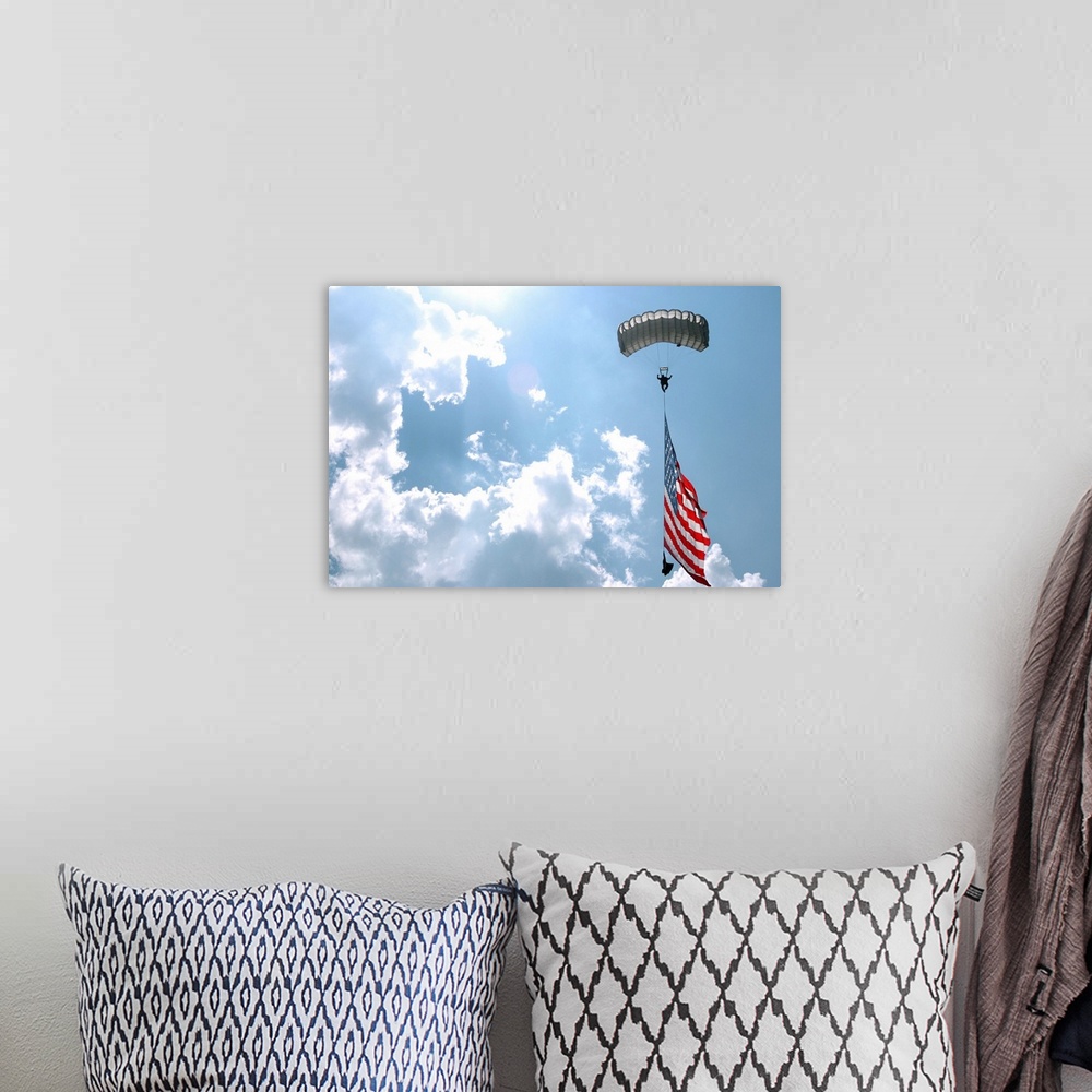 A bohemian room featuring A skydiver carries a U.S. flag while descending through the sky.