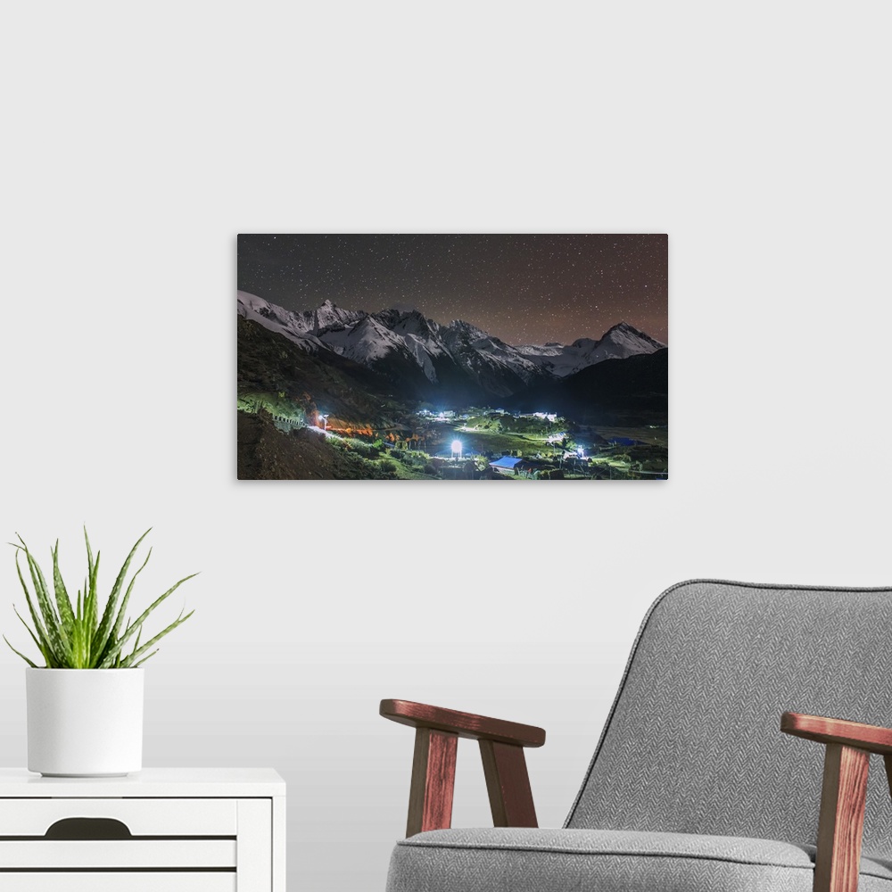 A modern room featuring A starry night in Laigu village, Tibet, China. Moonlight illumates the snow mountains in the back...